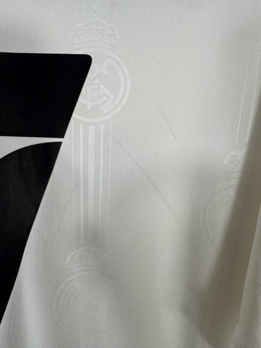 Gros plan du tissu jacquard à écussons du maillot Real Madrid 2022-2023, état du blanc