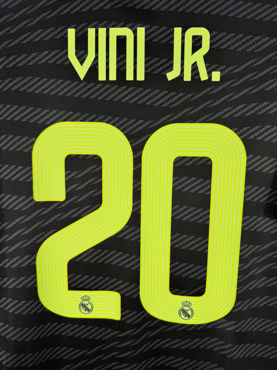 Détail flocage Vini Jr. 20 jaune fluo avec écusson du club, maillot Real Madrid third 2022-2023