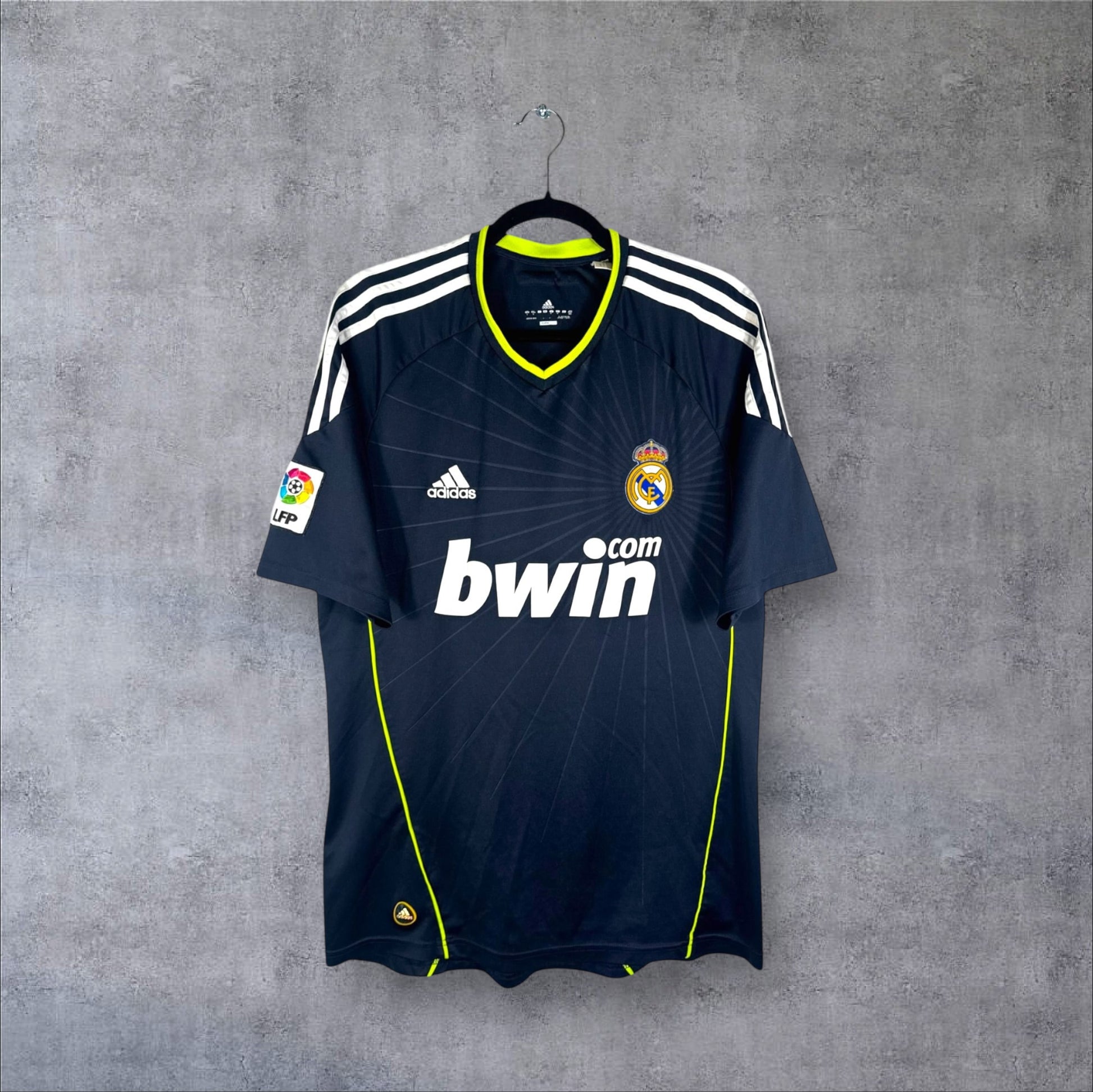 Vue de face du maillot Real Madrid 2010/11 Extérieur bleu nuit avec liserés vert fluo et sponsor bwin.com.