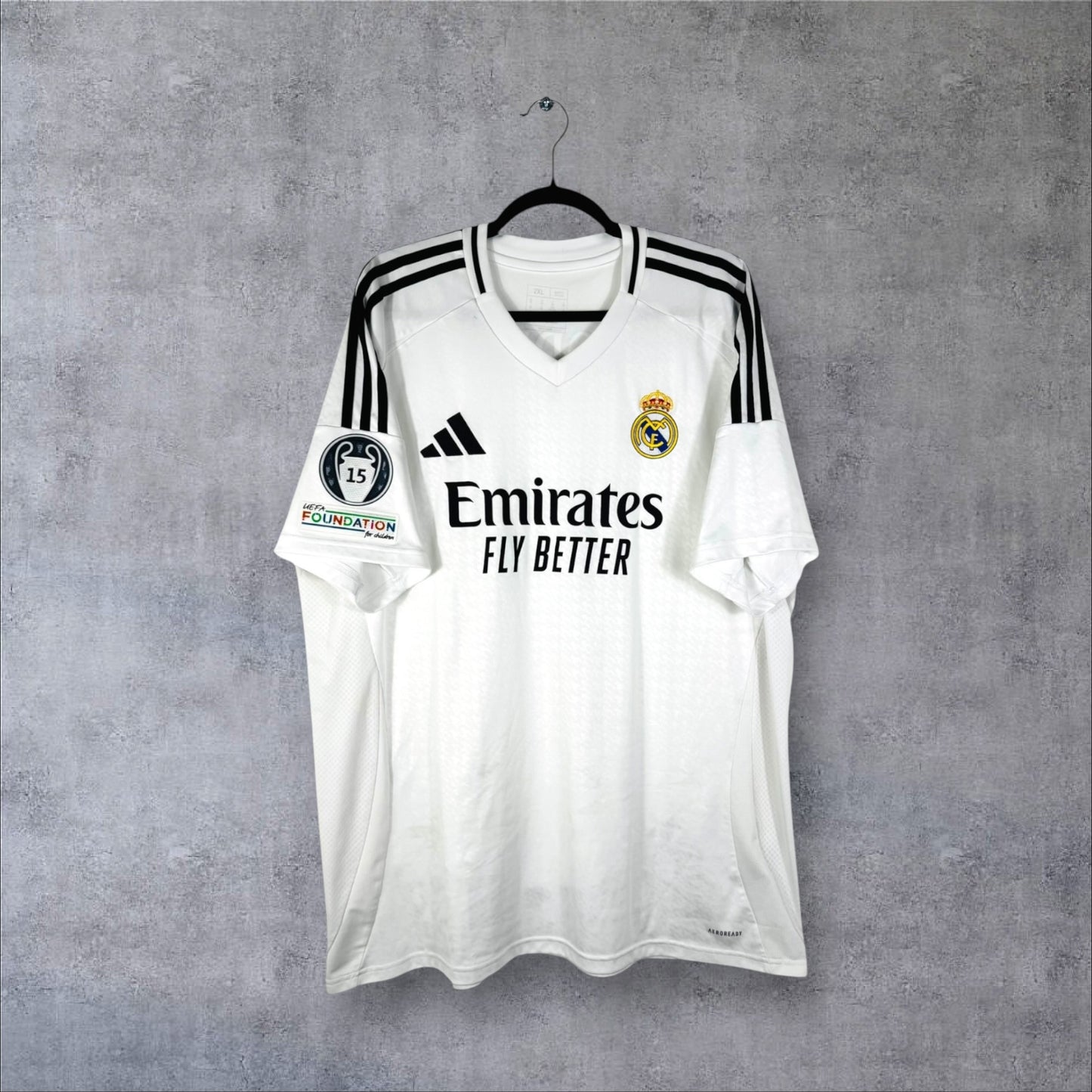Vue de face du maillot Real Madrid 2024-2025 domicile blanc avec sponsor Emirates et col en V.