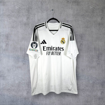 Vue de face du maillot Real Madrid 2024-2025 domicile blanc avec sponsor Emirates et col en V.