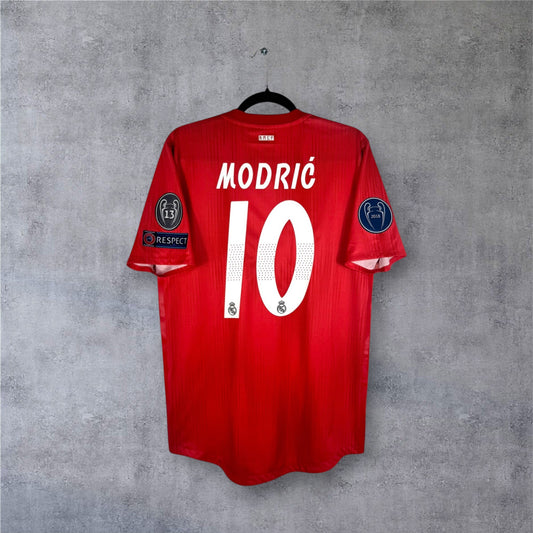 Flocage officiel blanc MODRIC numéro 10 et patchs LDC sur maillot Authentic Real Madrid.