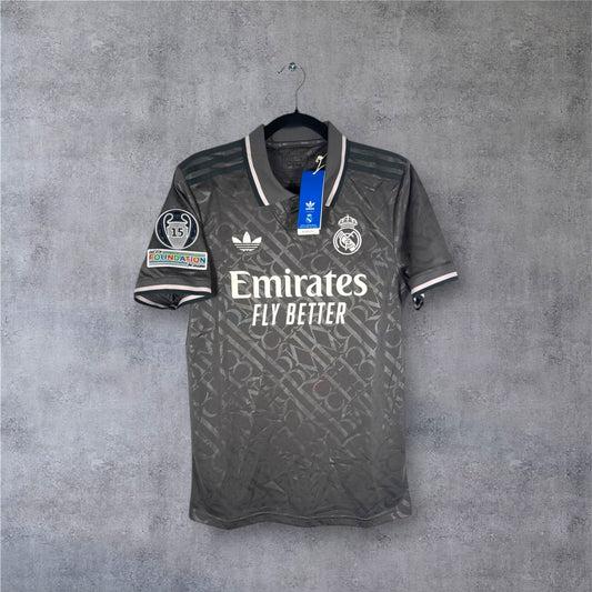 Vue de face du maillot Real Madrid Third 2025 gris avec logo Adidas Trèfle et motif RMCF.