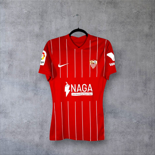 Vue de face du maillot Sevilla FC 2021-2022 extérieur rouge à rayures blanches fines avec sponsor NAGA.