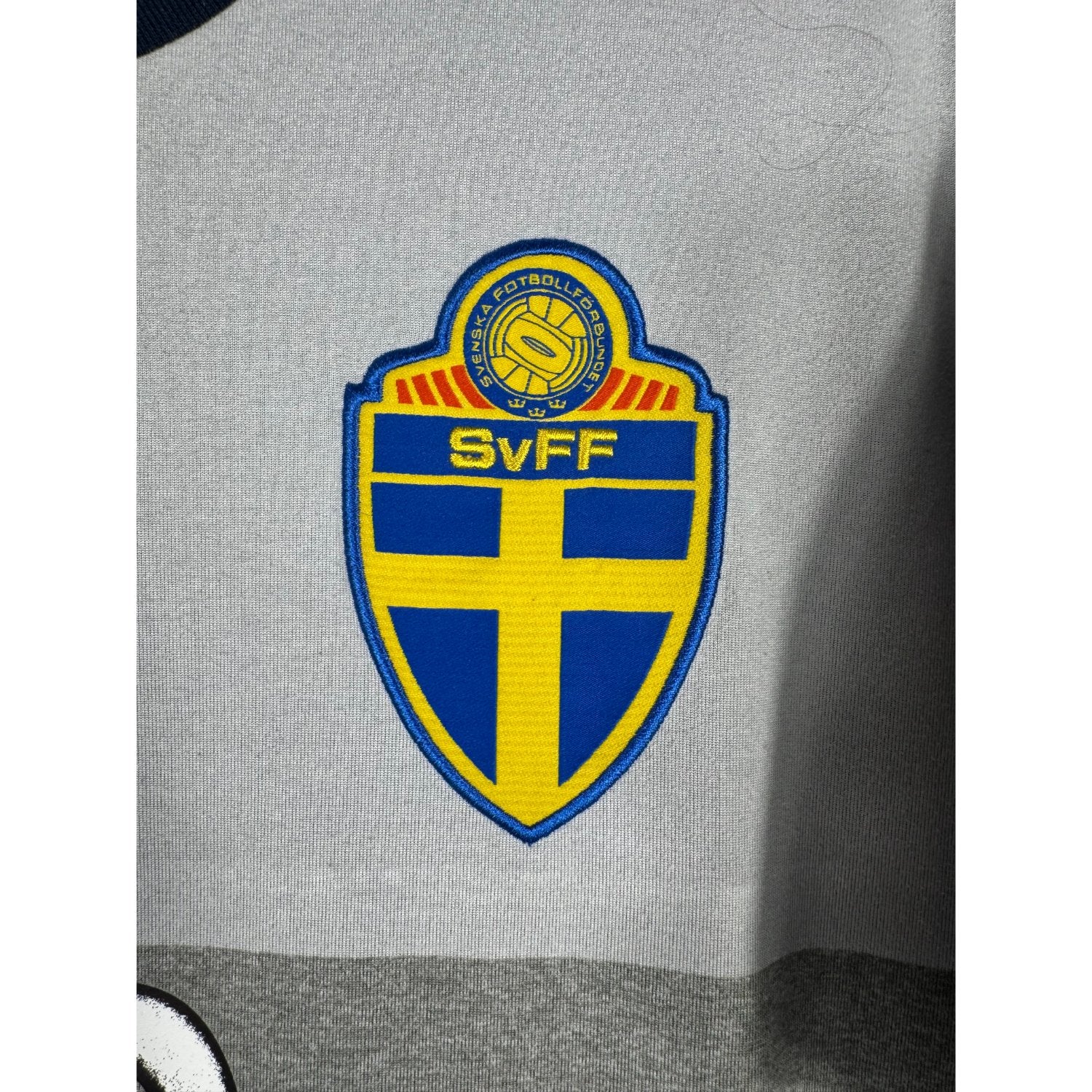 Détail de l'écusson de la Suède et du logo Adidas