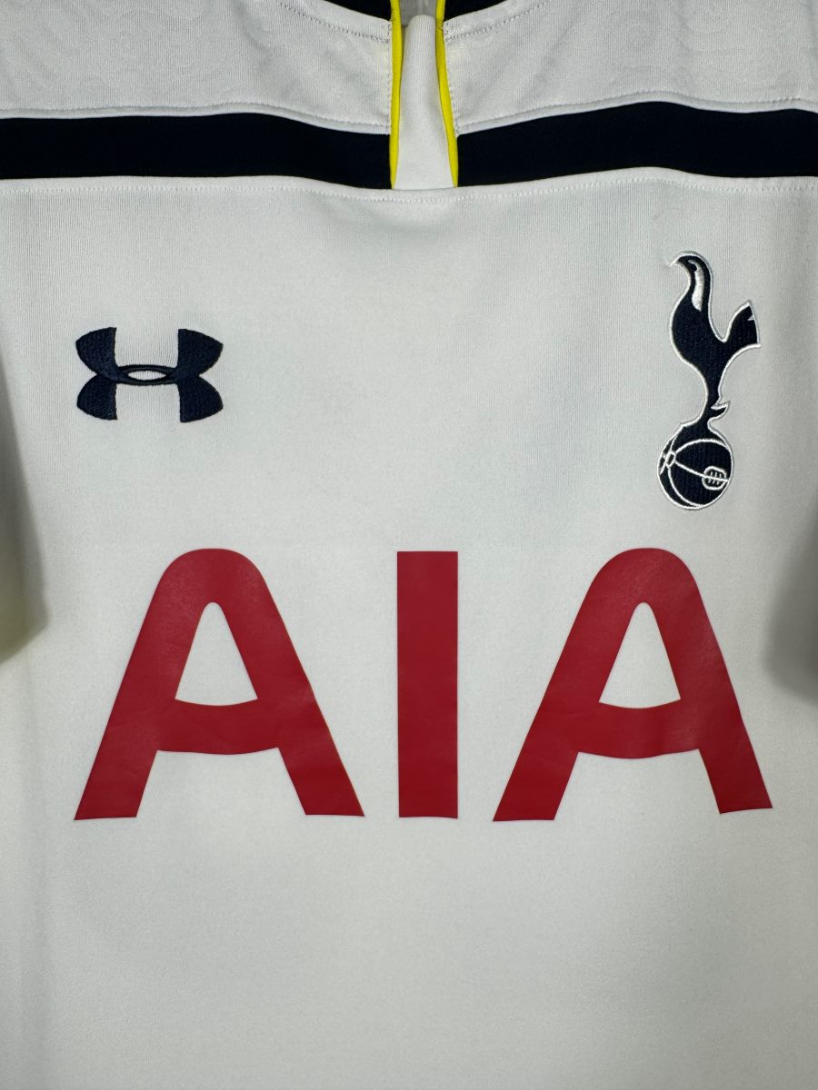 Détail du blason coq Tottenham brodé et du logo Under Armour sur le maillot domicile 2014-2015