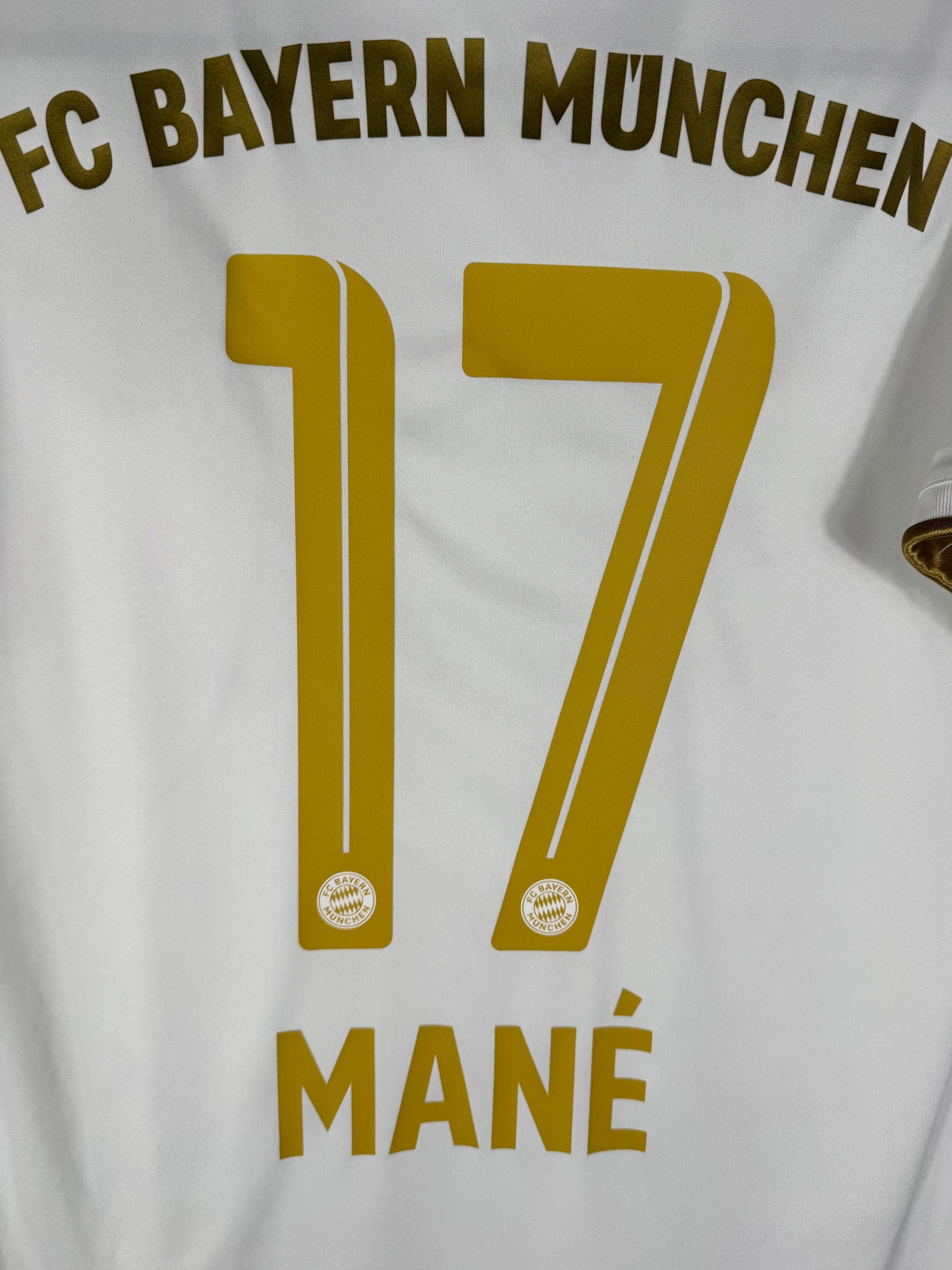 Zoom sur le numéro 17 doré de Sadio Mané avec typographie officielle Ligue des Champions du Bayern.